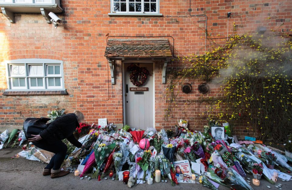  A woman lays flowers in tribute following the tragic death of the pop icon