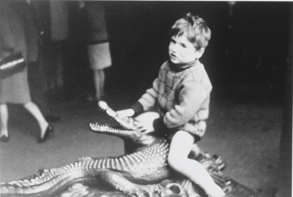  This vintage photo from George Michael's family album shows him sitting on a model crocodile aged five