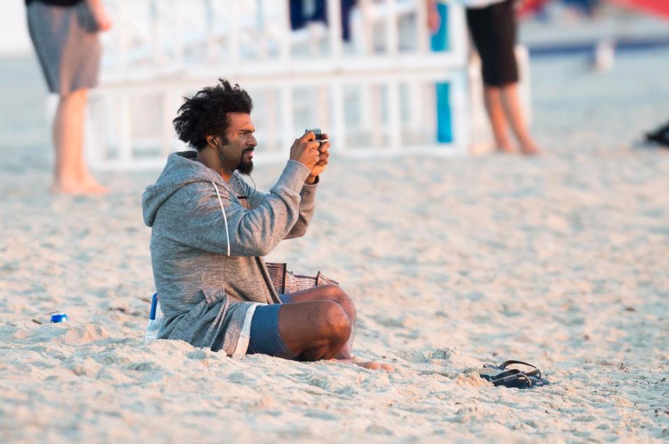  David Haye appears to be taking a selfie on the beach as he sits in the sand