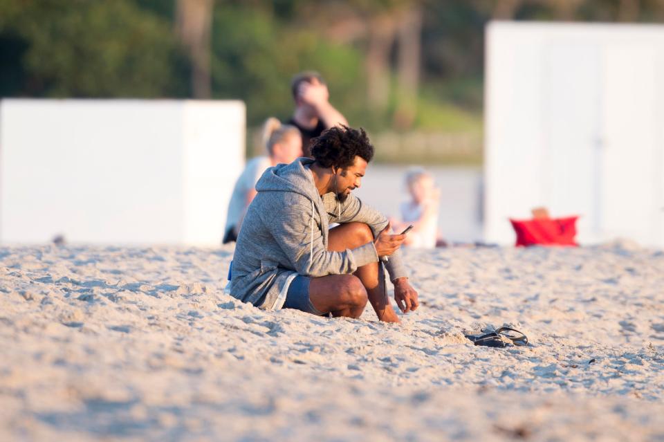  David Haye checks his phone as he sits on his own at the beach