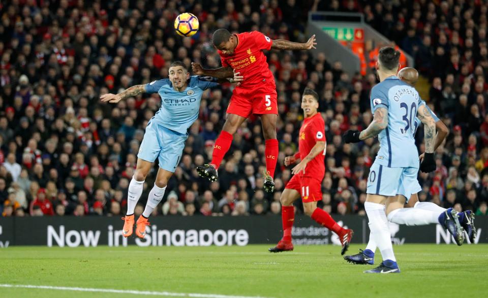  Georginio Wijnaldum leaps above Aleksandar Kolarov to open the scoring at Anfield