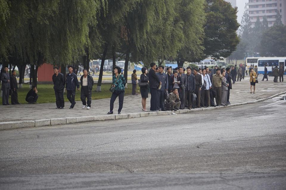  Relatively well-off citizens in the capital Pyongyang still huddle together in raggedy clothes as they wait for a bus