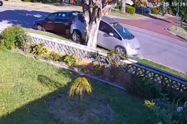 The car slams into the parked car and then struggles to get free