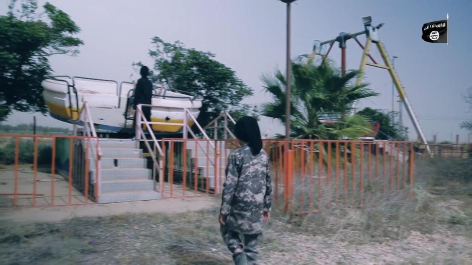  The young boy is seen here walking towards an abandoned ride in the Syrian park, where the killing will take place