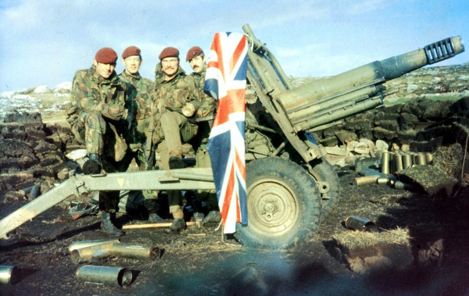  Troops pose for a photo next to the British flag