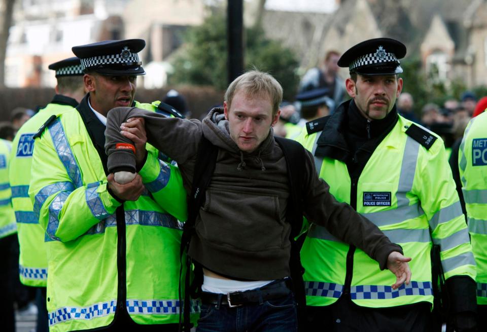  A demonstrator is carried away by police during protest against fascism outside the Houses of Parliament, following a visit by the controversial Dutch politician Geert Wilders