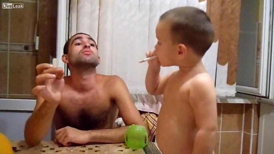 Grabs from footage posted online which reportedly shows a father in Russia giving his toddler son a cigarette to smoke