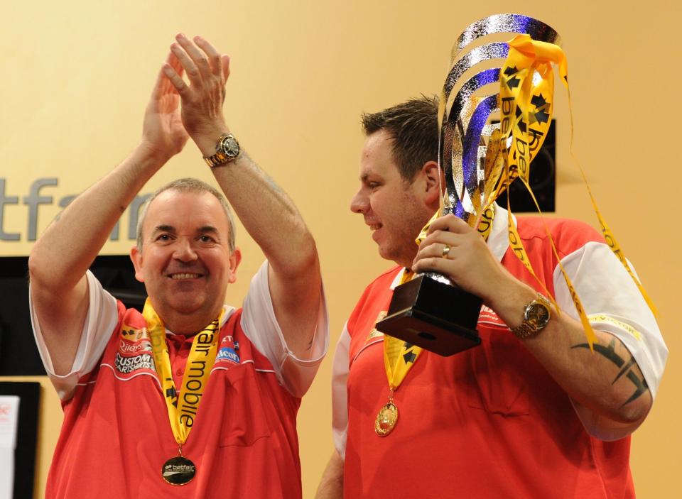  England's 16 time world champion Phil Taylor and Adrian Lewis celebrate their victory over Belgium in the final at the World Cup of Darts