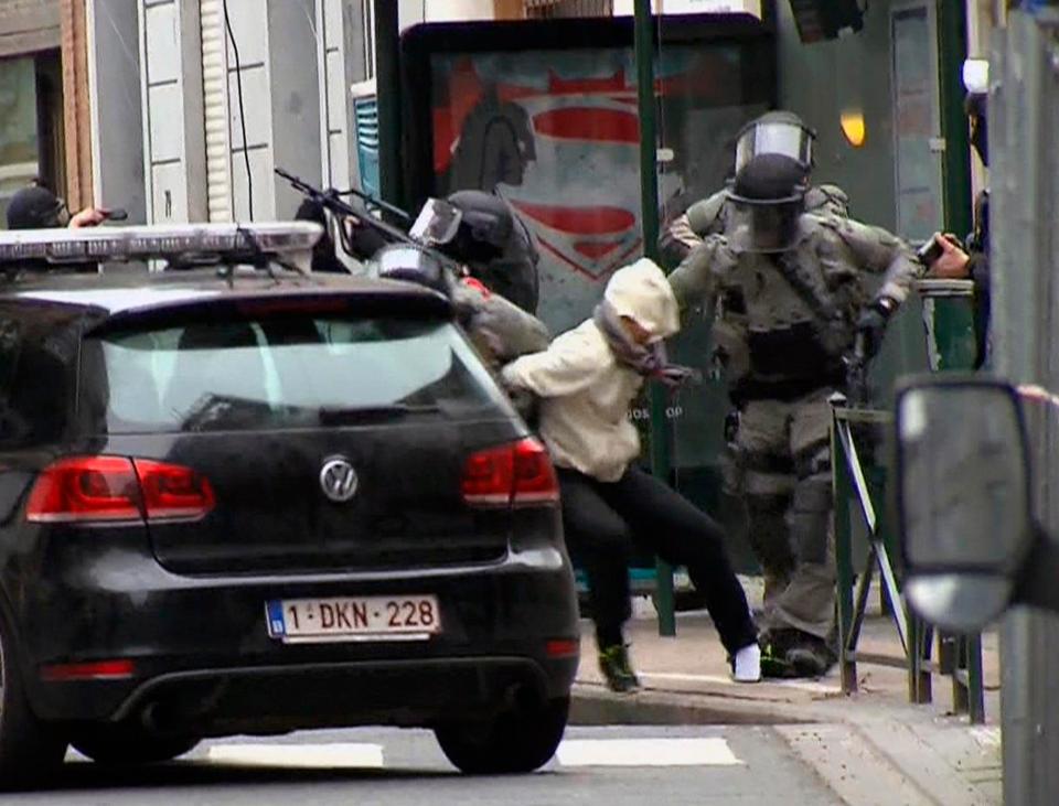  Salah Abdeslam, centre, is arrested by police and bundled into a police vehicle