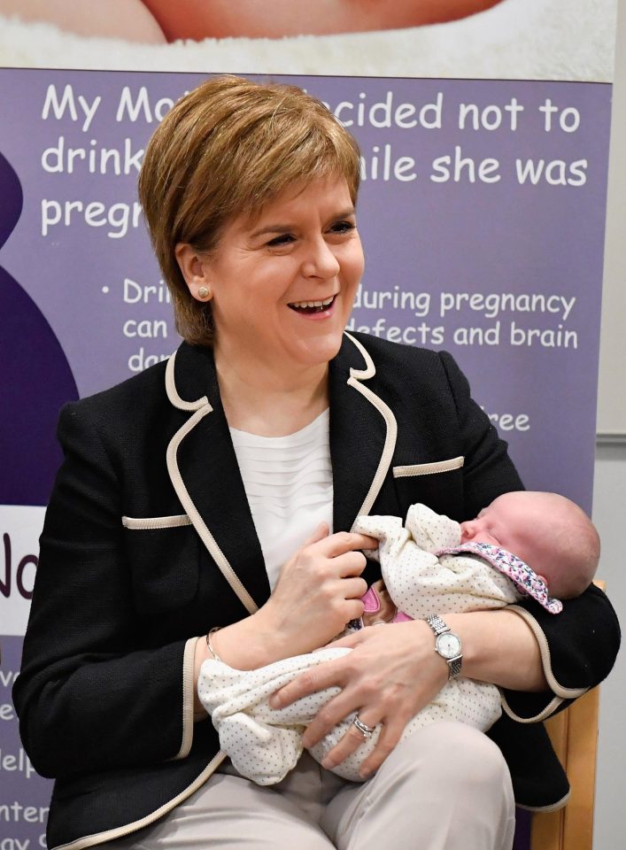  First Minister Nicola Sturgeon holds a newborn as they hand out baby boxes as part of a pilot which will help new mums in Orkney