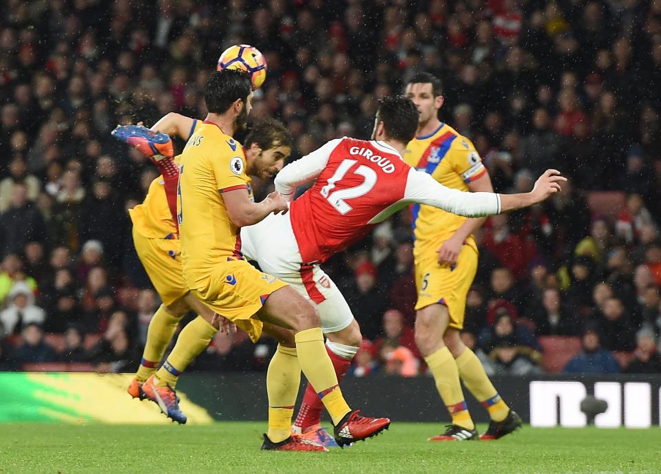 Olivier Giroud flicks his heel to meet Alexis Sanchez's cross as it goes in off the underside of the bar