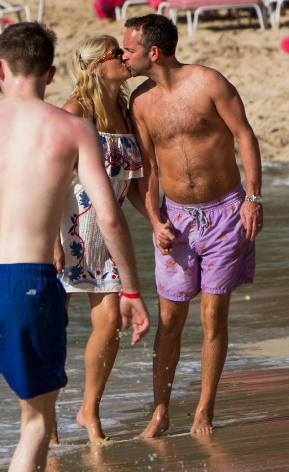  The couple have a kiss as they hold hands on the beach