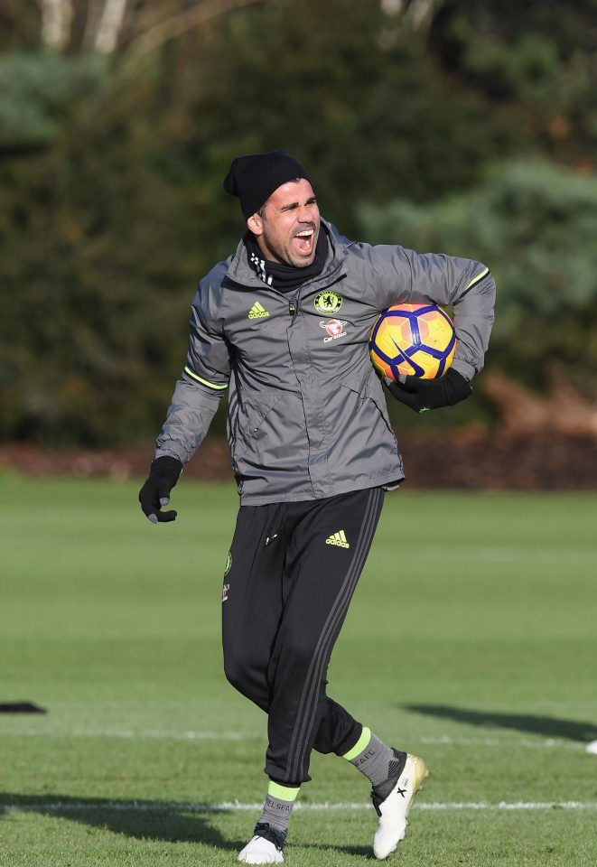  Diego Costa laughs at a joke in training as he carries a Premier League ball under his arm