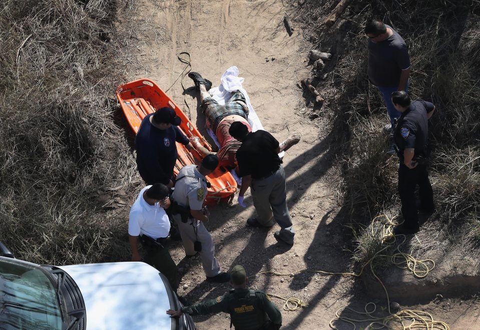  Authorities pull a dead body from the Rio Grande river