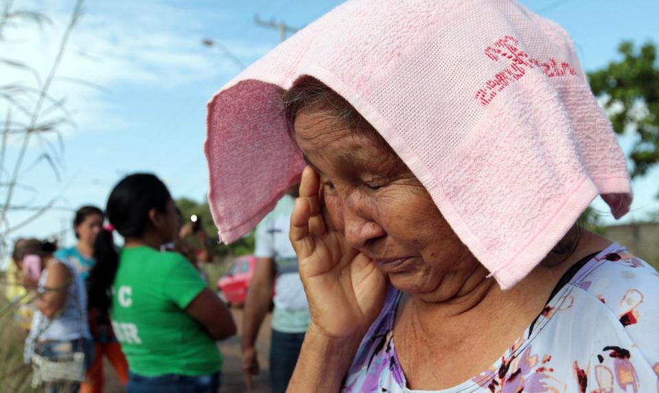  A woman wipes away her tears as she waits nervously outside the prison