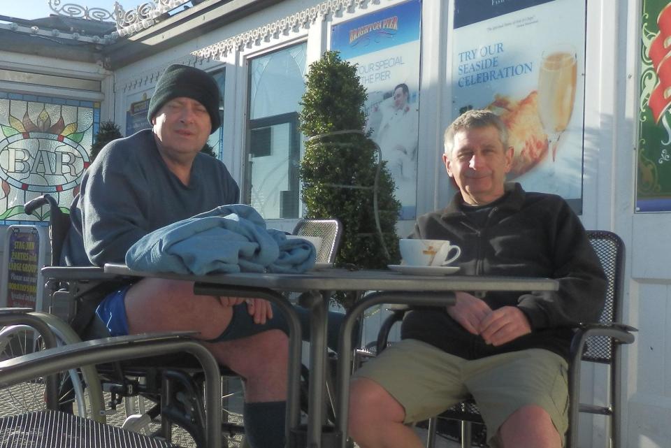  His carer (right) tried to explain to staff that John’s MS meant he could not control his movements