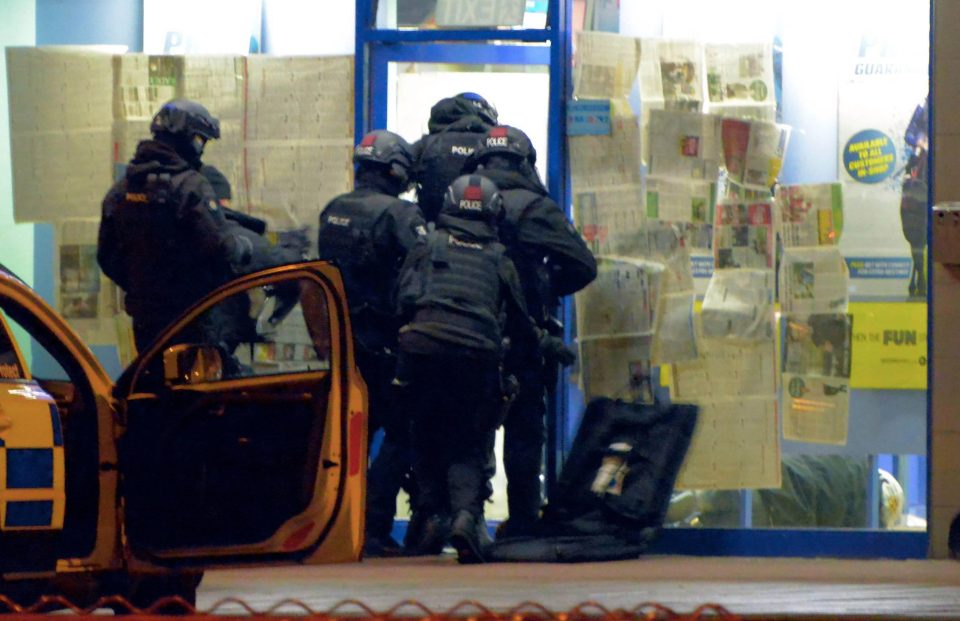  Armed police storm the shop with the suspect apparently bundled to the floor