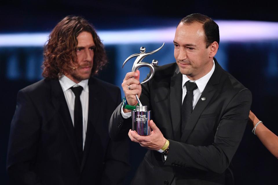  Colombian executive and chairman of Atletico Nacional Juan Carlos de la Cuesta (R) holds The 2016 FIFA Fair Play Award next to former Spanish football player Carles Puyol