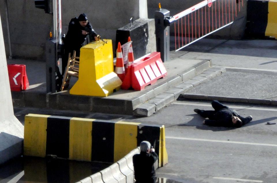  Officers point their guns at the shooter as he lies on the ground outside the police station