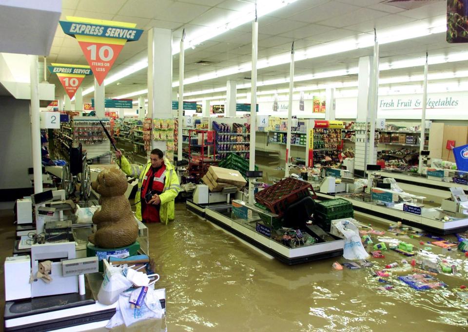  A gas inspector wades through a flooded supermarket in the centre of Uckfield in 2000