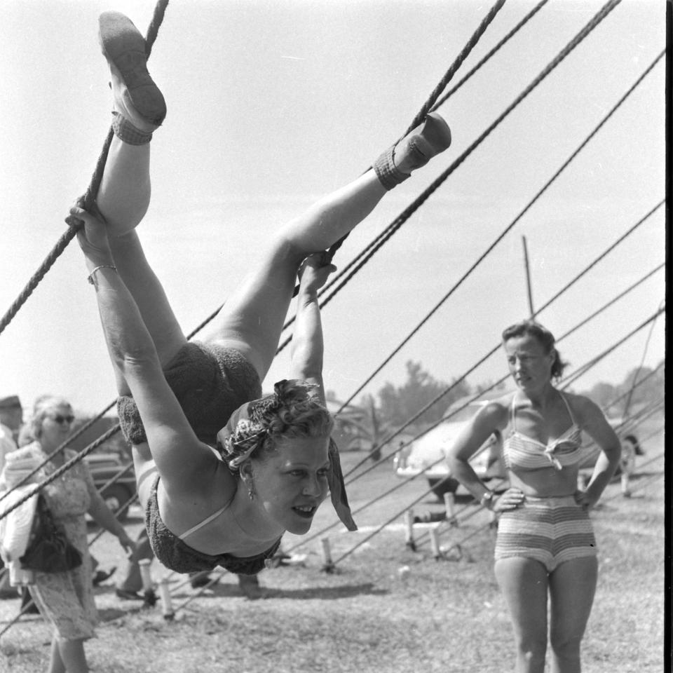  A dangling acrobat can be seen suspended from a pair of ropes in one historical photo