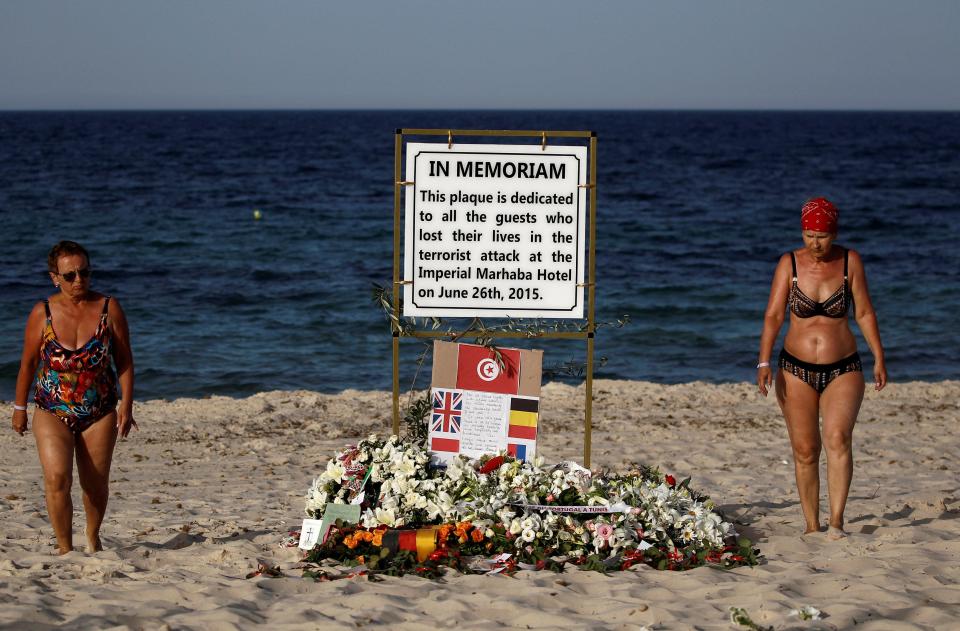  Tourists pass a plaque dedicated to victims on the beach of the Imperial Marhaba resort