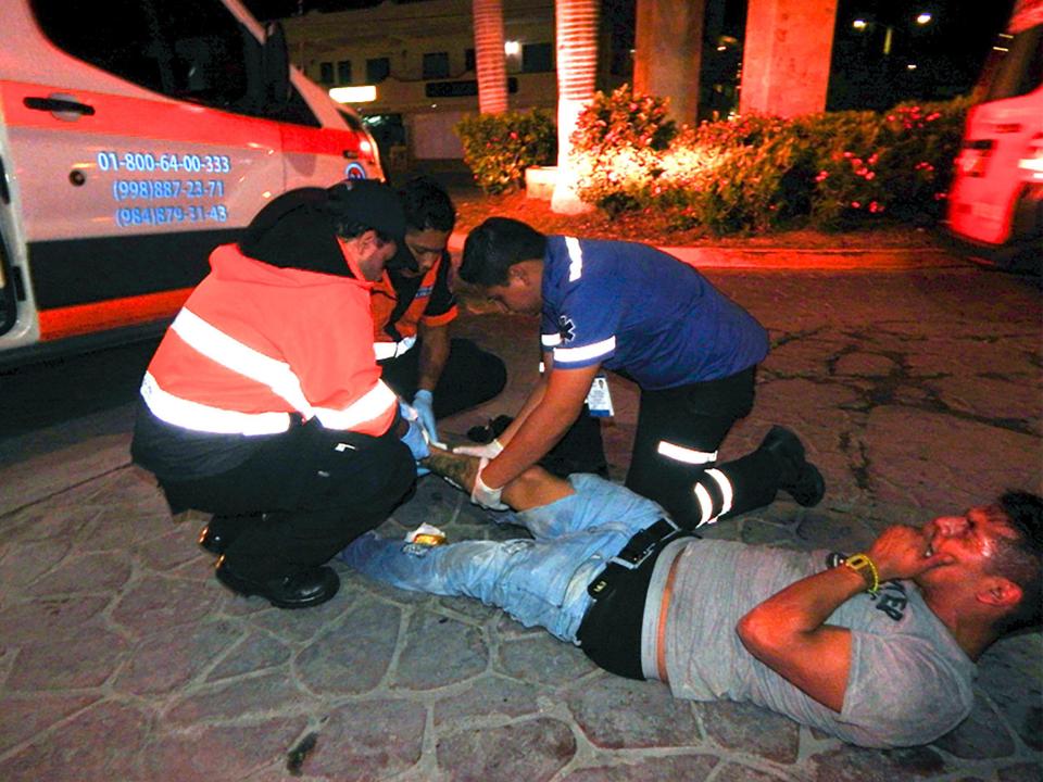  A man with an injured leg is treated on the ground by medics