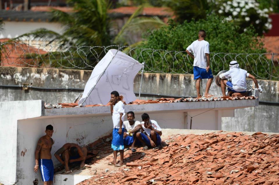  Prisoners stand on the rooftop of the Alcacuz prison in Natal