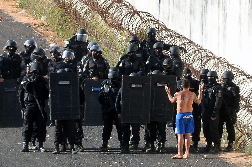  A prisoner pleads with police as they put an end to the extreme violence that broke out on Saturday