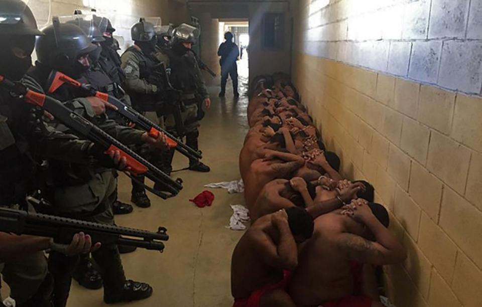  Heavily armed guards keep a group of prisoners in check as 240 are moved to a different jail