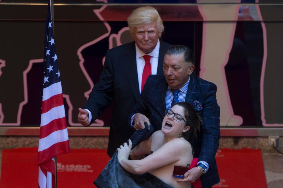  She is led away from the Trump waxwork at a museum in Spain