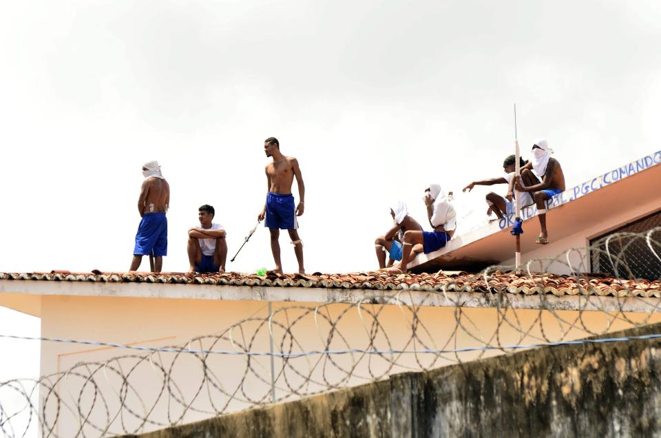  Bloodthirsty criminals stand on the rooftops of Alcacuz prison days after 26 people were killed, many of whom were beheaded