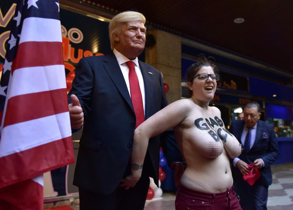  Topless FEMEN protester jumped the ropes to get her hands on the Trump waxwork