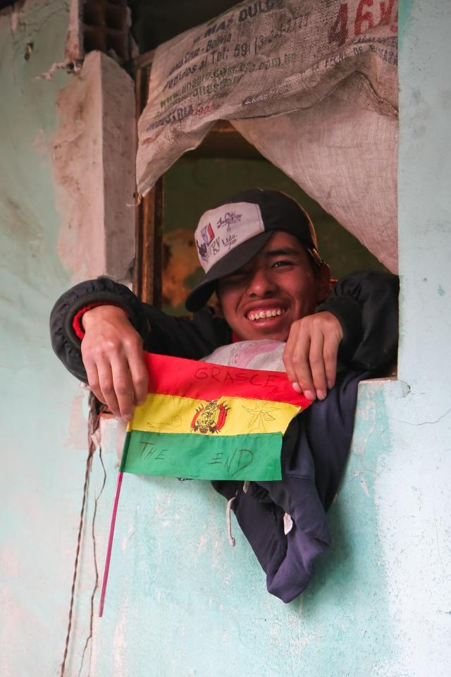 A smiling inmate clutching the Bolivian flag was pictured inside the jail