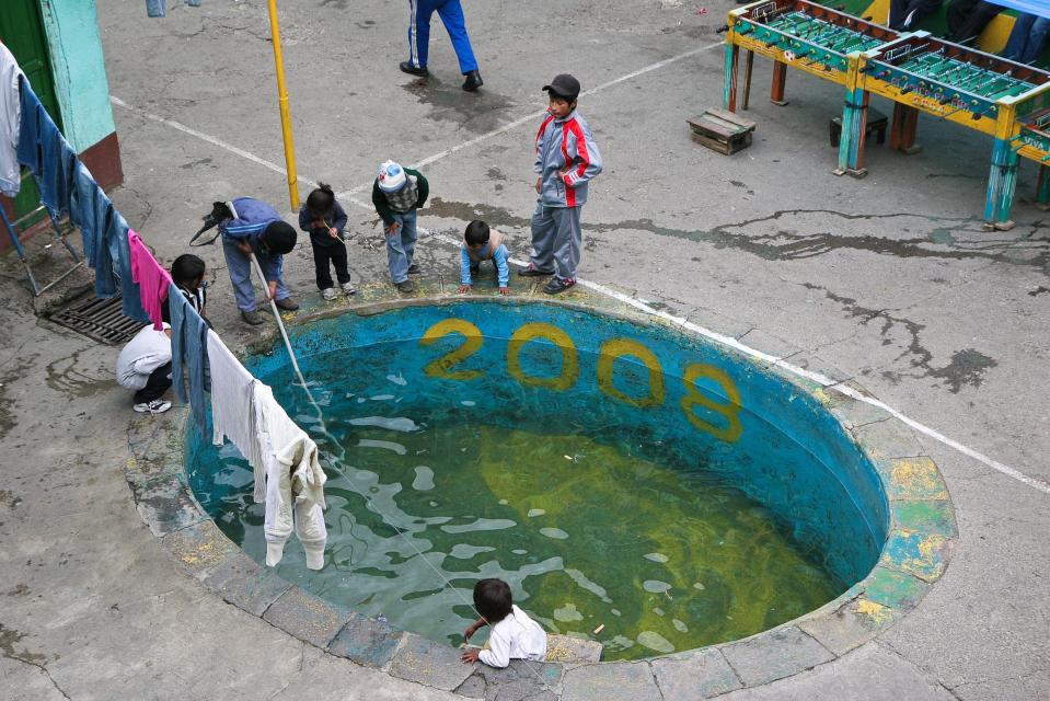 Kids can be seen around a pool doing laundry inside the jail, where inmates are allowed to live with their families