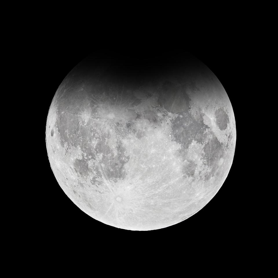  During the rare astronomical occurrence, the Moon's surface has a dark shadow cast over it