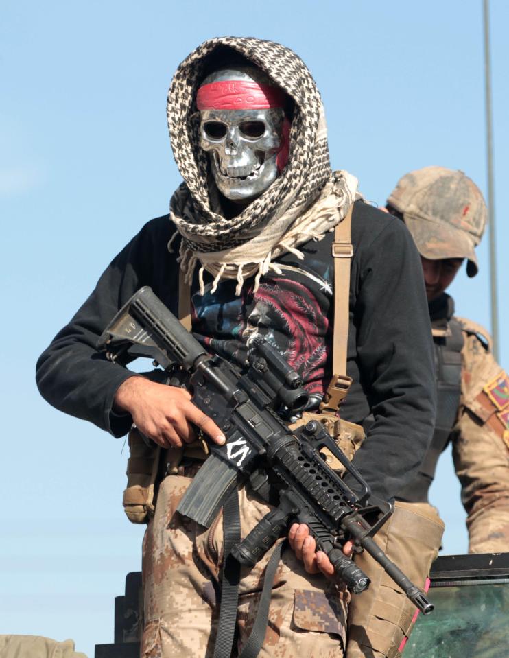  A masked Iraqi counter-terrorism service member (CTS) poses for a picture after the liberation of Mosul