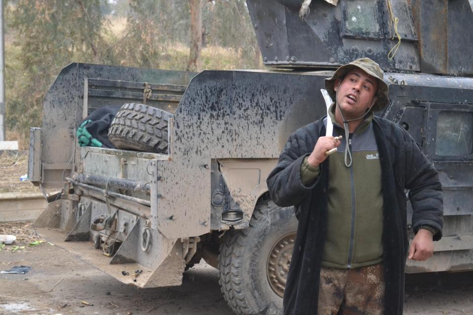  An Iraqi soldier poses with a sword in east Mosul