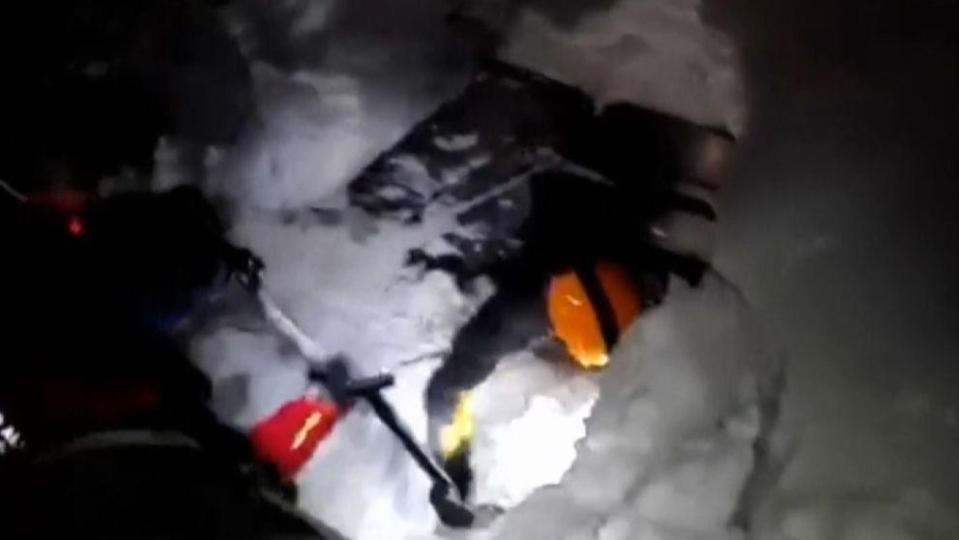  Rescuers dig through the snow in the desperate search for survivors last night