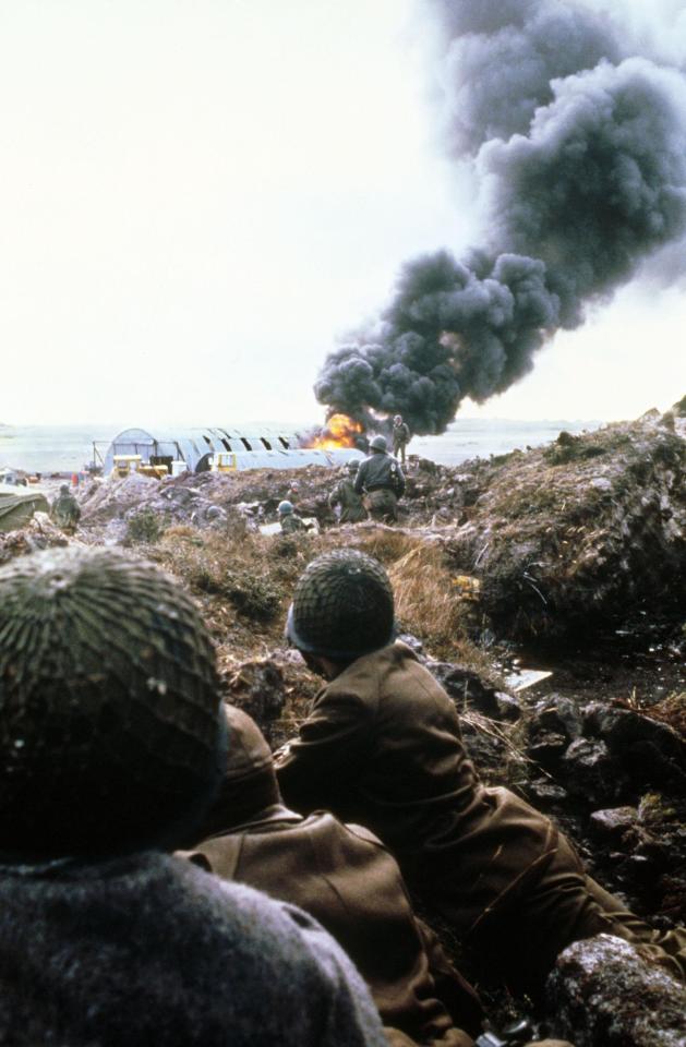  British troops watch a building go up in flames in Port Stanley during the 1982 Falklands War