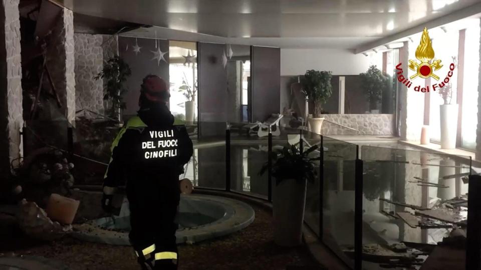  A rescue worker walks through one of the rooms inside the buried hotel after accessing part of the building