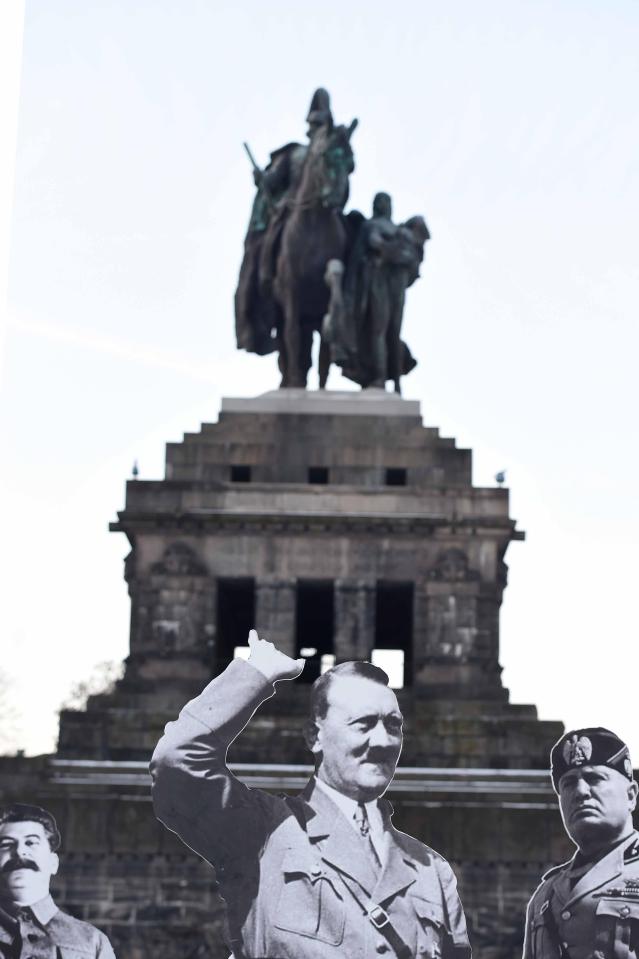  Demonstrators holding cardboard cut-outs depicting Soviet dictator Joseph Stalin, German dictator Adolf Hitler and Italian dictator Benito Mussolini during a protest against a meeting of the main leaders of Europe's populist and far-right parties in Koblenz