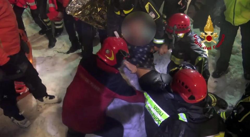  Rescued people are treated by emergency workers after spending more than two days buried in the rubble