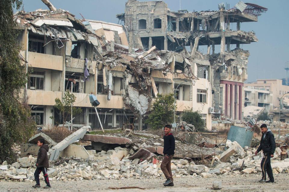  Iraqi boys walk near the University of Mosul after its liberation from ISIS