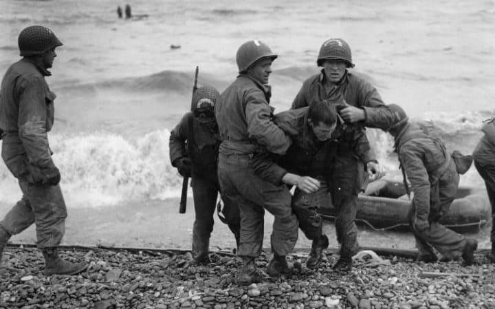  1944: Medics from the US 5th and 6th Engineer Special Brigade help wounded soldiers on Omaha beach