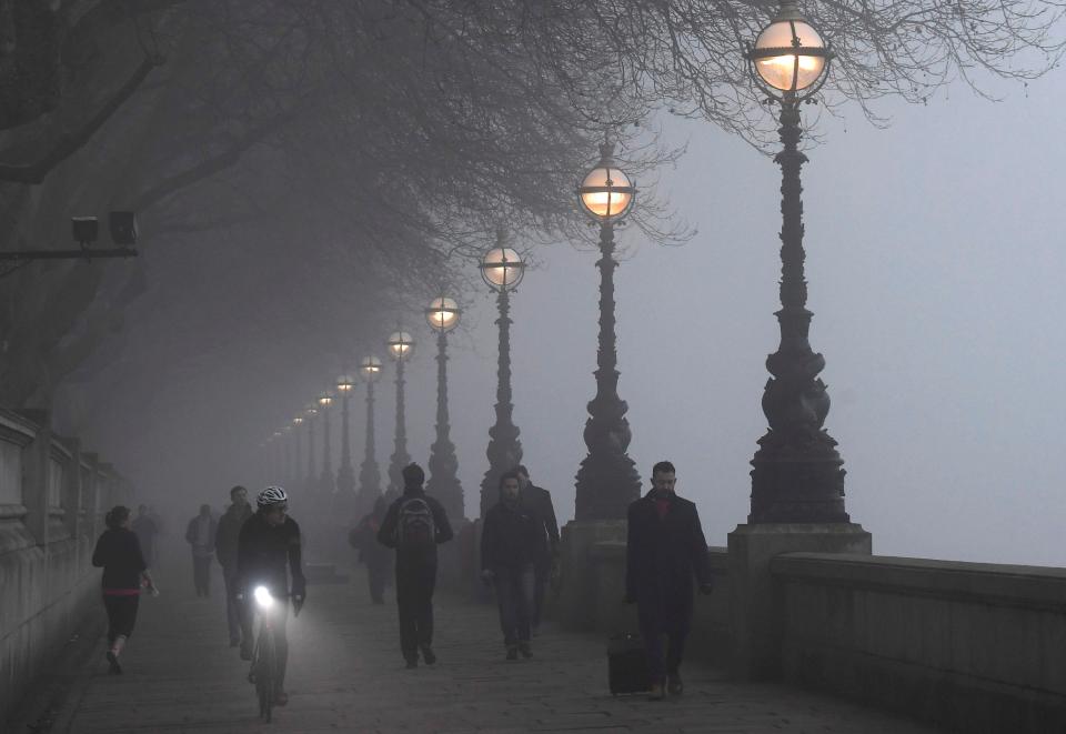  People walking along The Embankment in London during the foggy morning