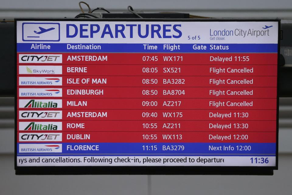  An electronic passenger information display board shows delayed or cancelled flights inside London City Airport