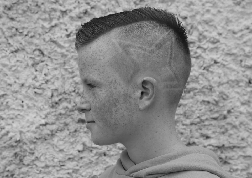  A lad with a mohican and a star shaved into his head