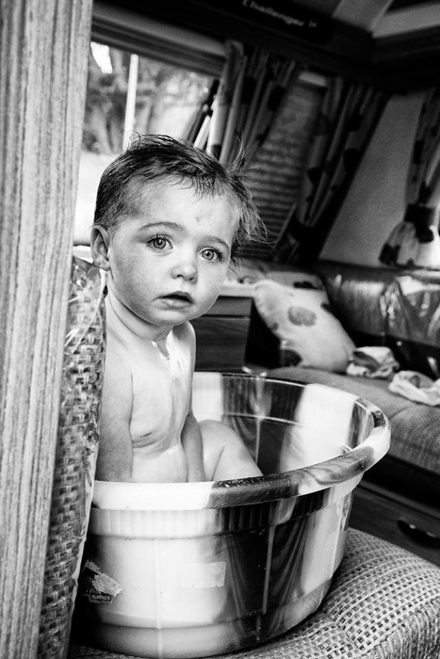  A cute little lad sits in a bowl for a wash