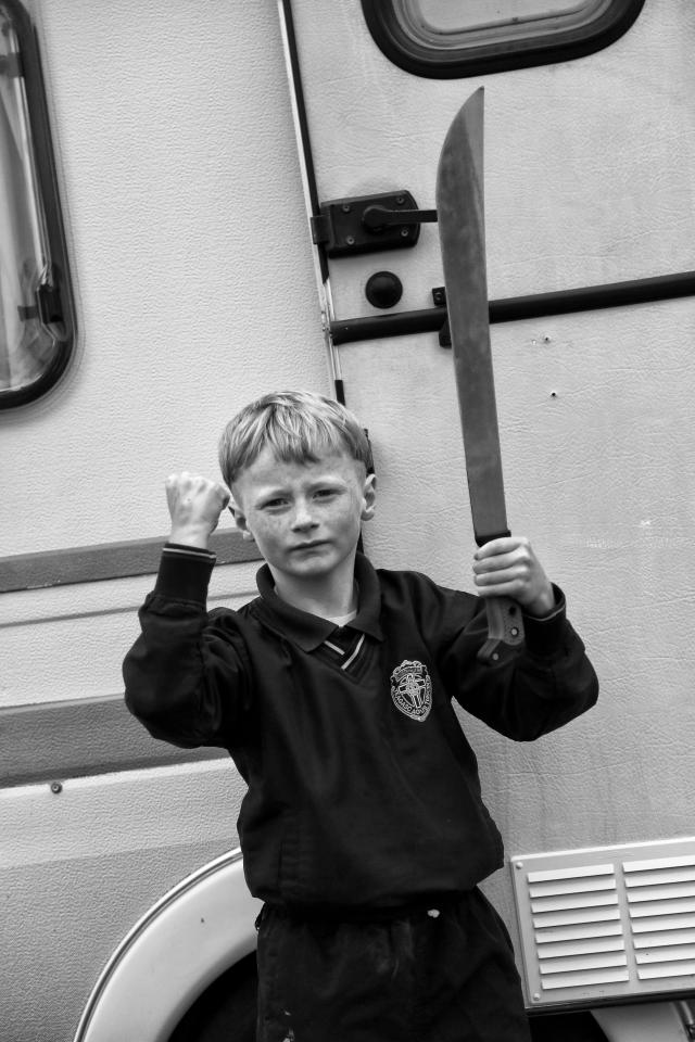  This little lad waves a defiant fist while brandishing a machete